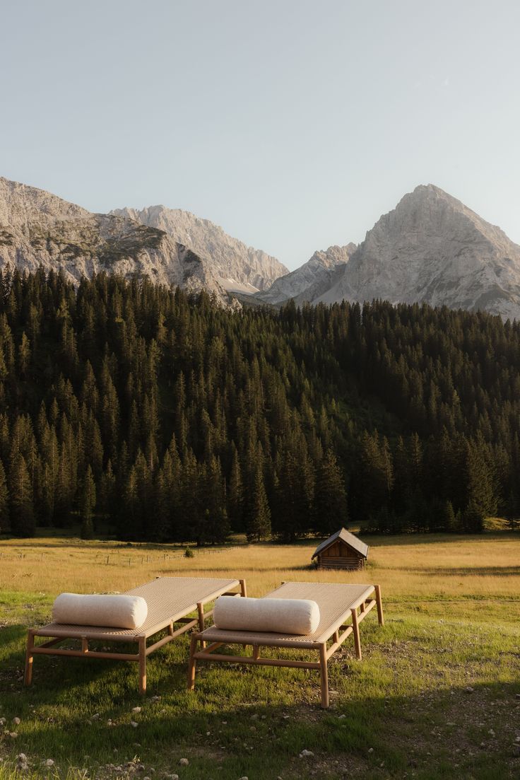 Serene mountain landscape with elegant lounge chairs looking out at forests and alpine peaks, Essor Social